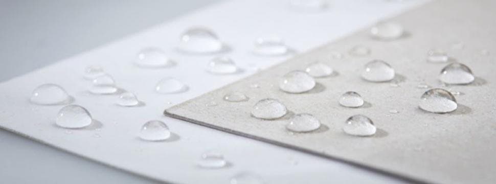 Gotas de água e gordura sobre o papel barreira New Mix, demonstrando resistência